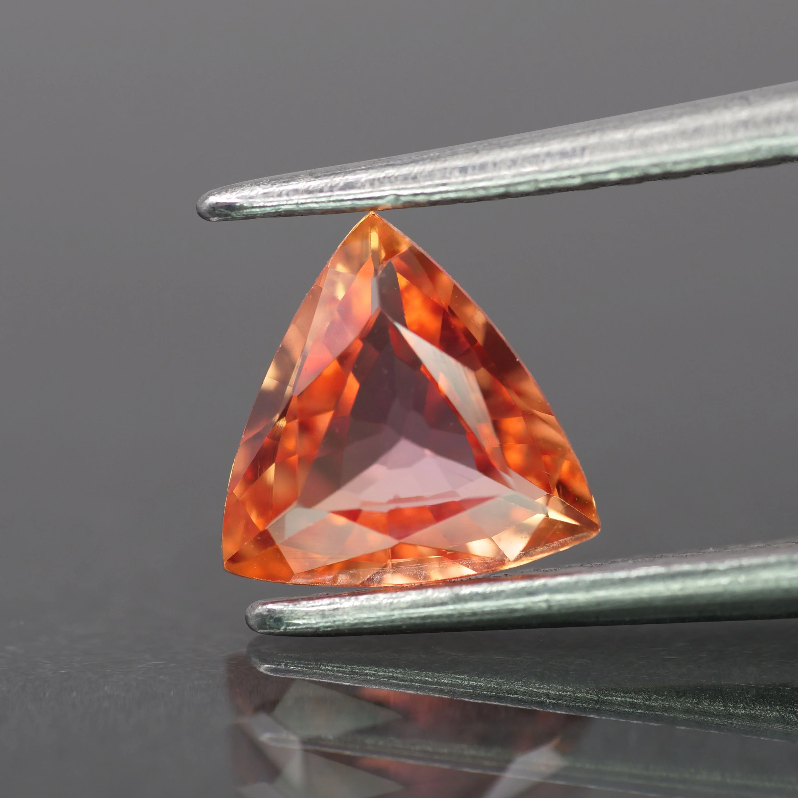 Sapphire | natural, redish orange color, trillion-cut, *6.5mm, 0.8ct, Madagascar