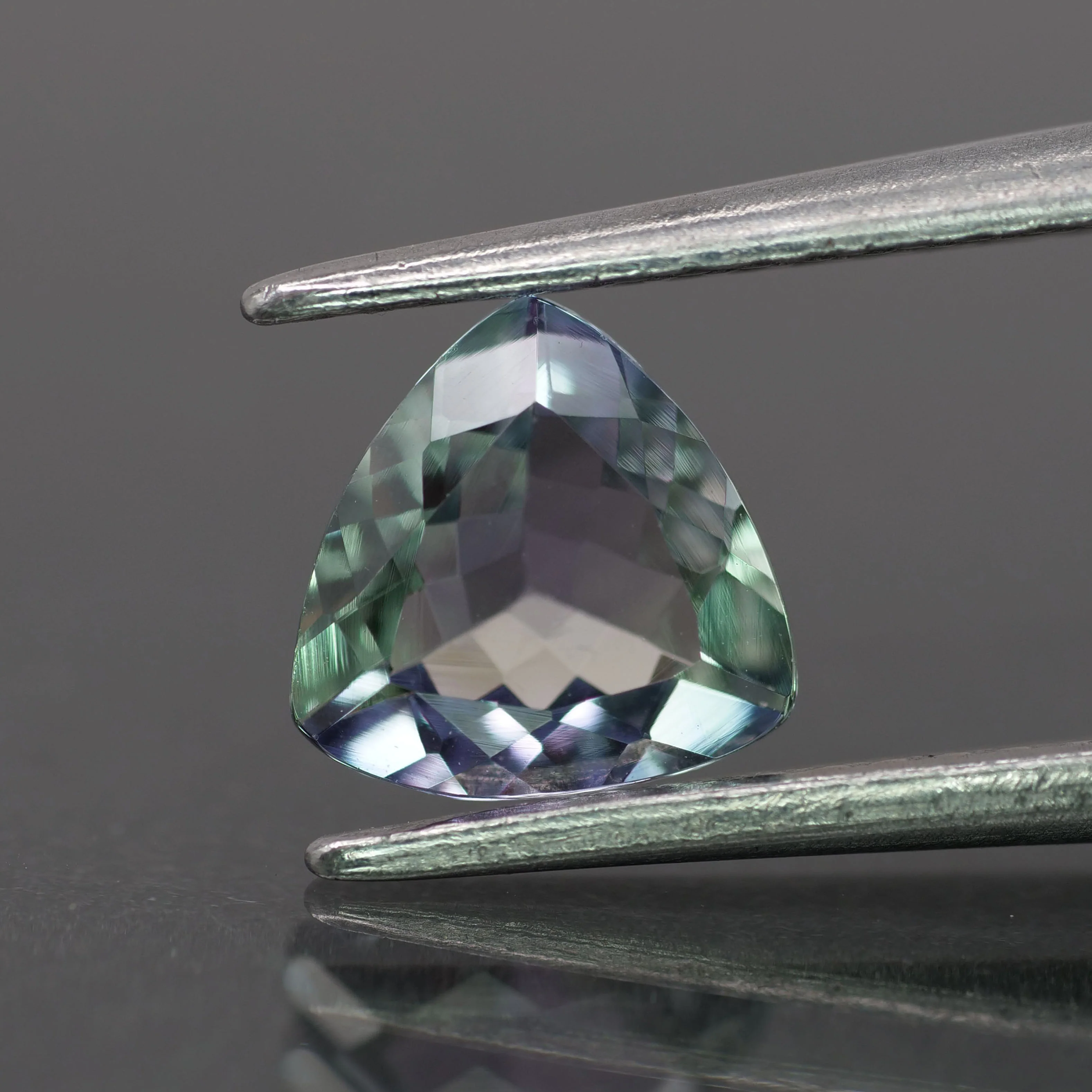 Tanzanite | natural, bi-color: purple & green color, trillion-cut, 6.5mm, 0.8ct